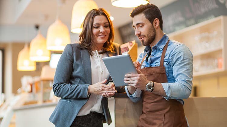 Photo of man and woman tracking shipments for small business
